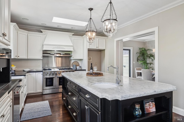kitchen with white cabinets, custom exhaust hood, appliances with stainless steel finishes, and dark cabinetry