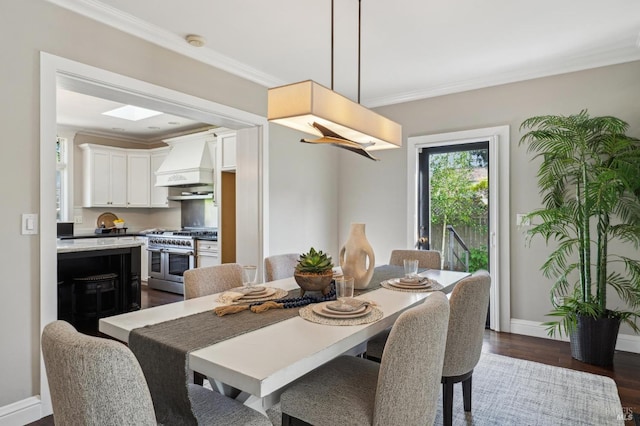 dining area with baseboards, ornamental molding, and dark wood-type flooring
