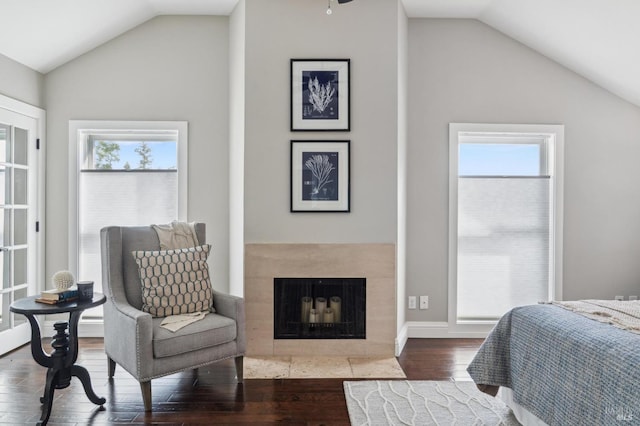 bedroom featuring a fireplace, hardwood / wood-style floors, vaulted ceiling, and multiple windows