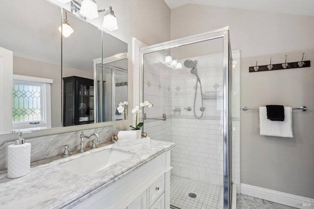 full bath with vaulted ceiling, a stall shower, and vanity