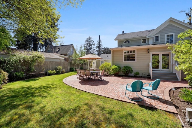 rear view of house featuring fence, french doors, a yard, and a patio