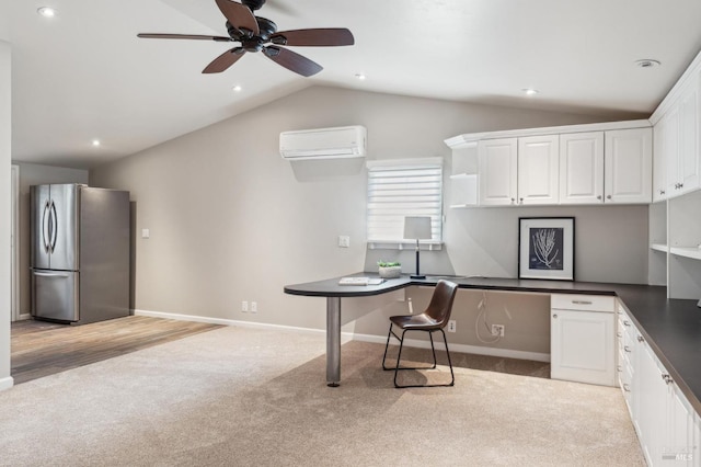 office area featuring vaulted ceiling, light carpet, ceiling fan, built in study area, and an AC wall unit