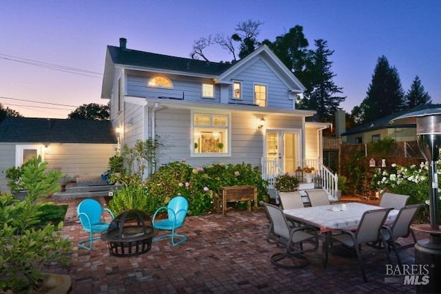 back of property featuring a patio, an outdoor fire pit, and french doors