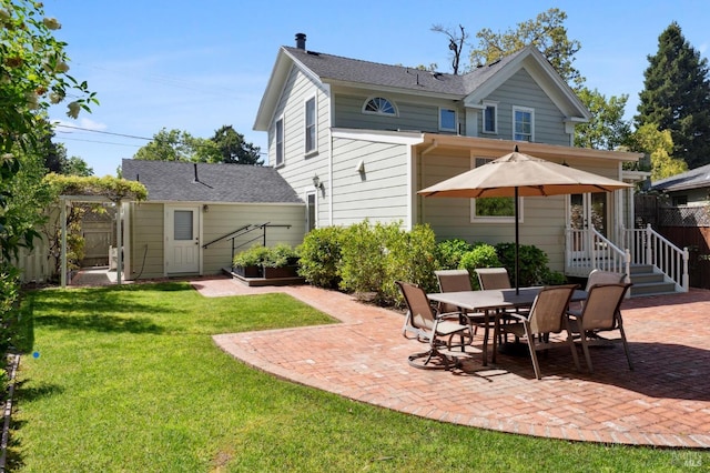 rear view of house with fence, a yard, and a patio area