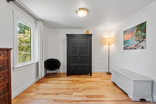 living area featuring light wood finished floors and baseboards
