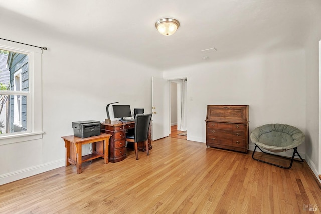 office area featuring baseboards, light wood-style floors, and plenty of natural light