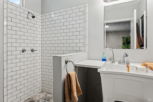 bathroom featuring tiled shower and vanity