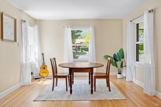 dining room featuring light wood-type flooring and baseboards