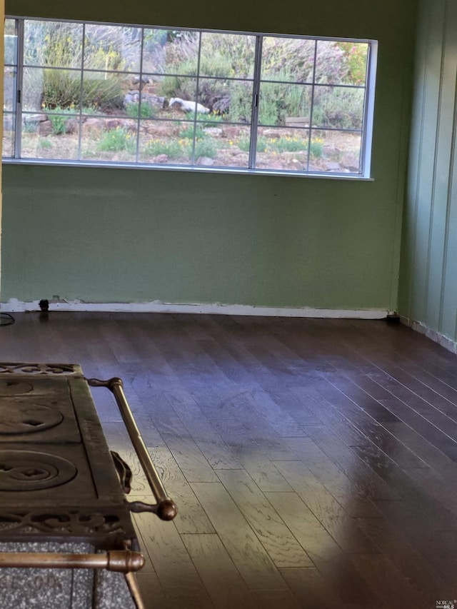 spare room featuring dark wood-style floors and baseboards