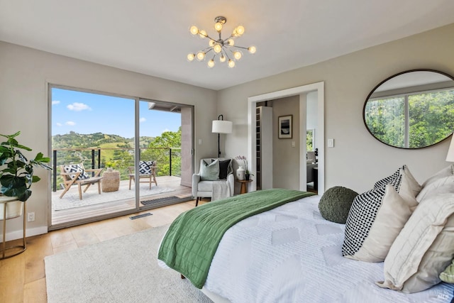 bedroom with a notable chandelier, access to outside, multiple windows, and light wood-type flooring