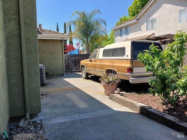 exterior space with central AC and fence