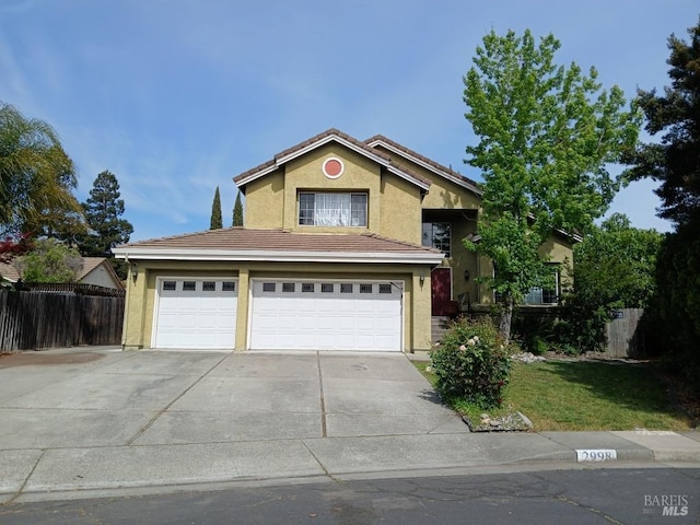 traditional-style home with a garage, fence, stucco siding, driveway, and a tile roof