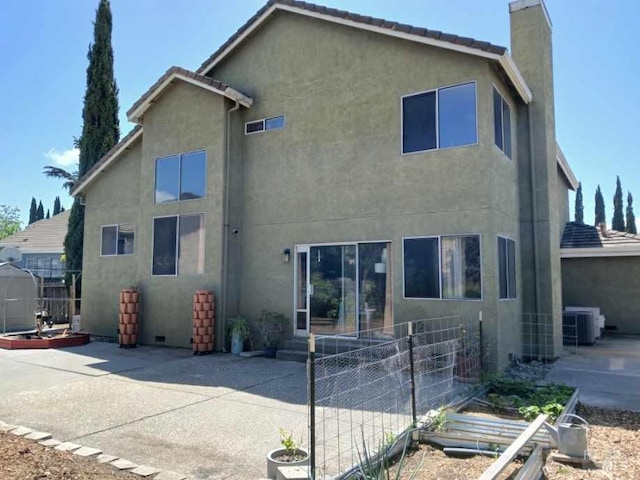 back of house featuring fence, central AC, stucco siding, a chimney, and a patio