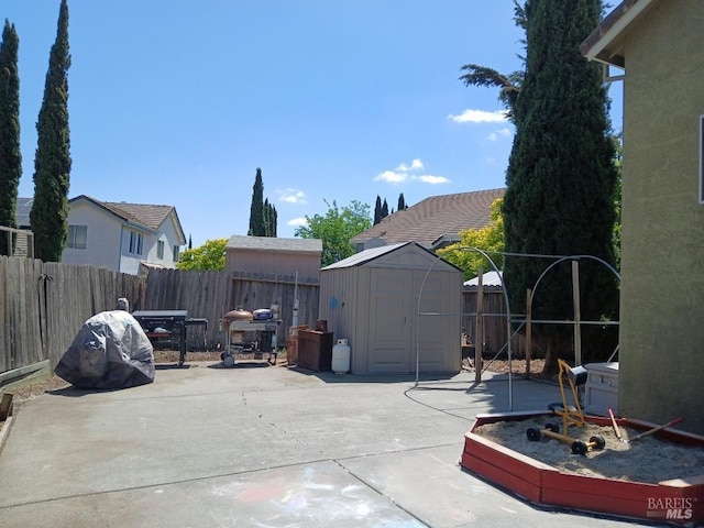 view of patio featuring an outdoor structure, a shed, and a fenced backyard