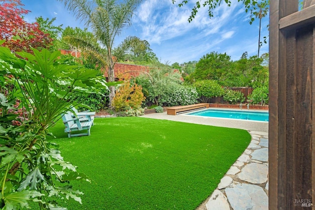 view of swimming pool with a fenced backyard, a fenced in pool, and a yard