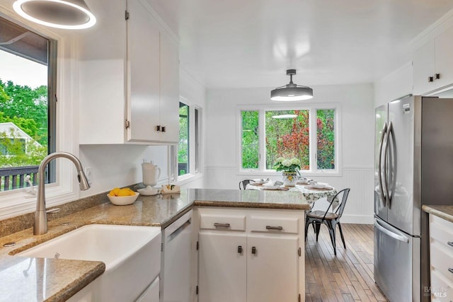 kitchen featuring a sink, white dishwasher, freestanding refrigerator, and a wealth of natural light
