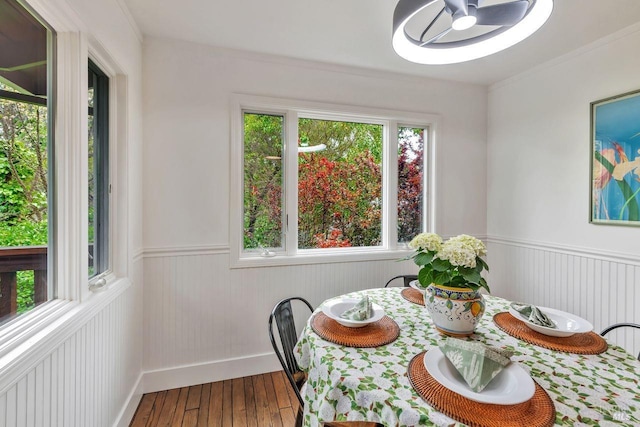 dining room with hardwood / wood-style flooring and a wainscoted wall