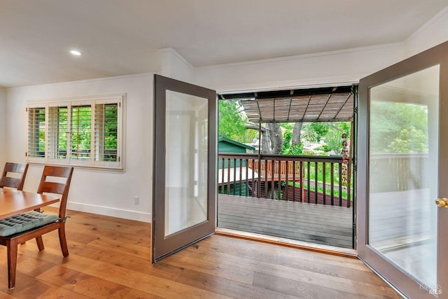 doorway to outside featuring baseboards, recessed lighting, wood-type flooring, and crown molding