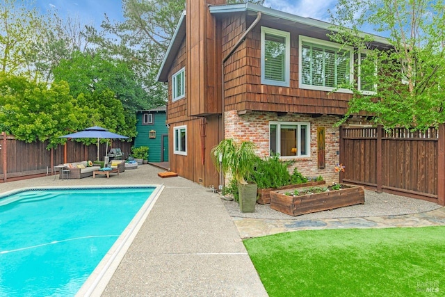 rear view of property featuring a fenced backyard, a fenced in pool, an outdoor living space, a garden, and a patio