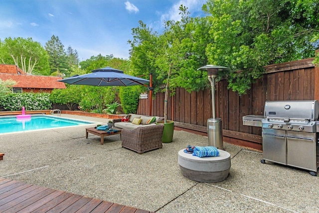 view of pool with a fenced backyard, grilling area, an outdoor living space, and a patio area