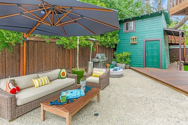 view of patio featuring a wooden deck, fence, grilling area, and an outdoor hangout area
