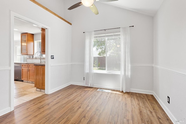 unfurnished room with light wood-type flooring, visible vents, a ceiling fan, and a sink