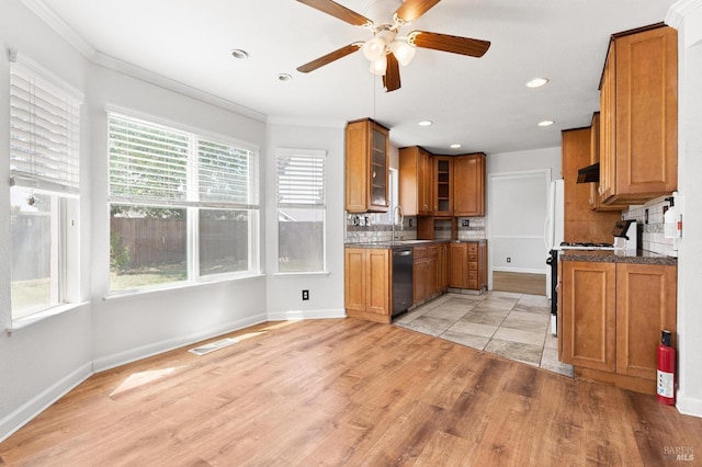 kitchen featuring ceiling fan, dishwashing machine, brown cabinets, and plenty of natural light