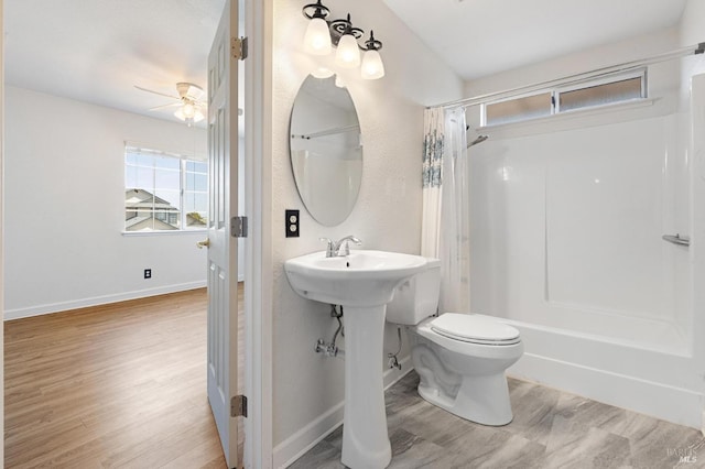 bathroom with baseboards, wood finished floors, ceiling fan, and toilet