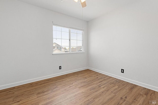 unfurnished room featuring baseboards, wood finished floors, and ceiling fan