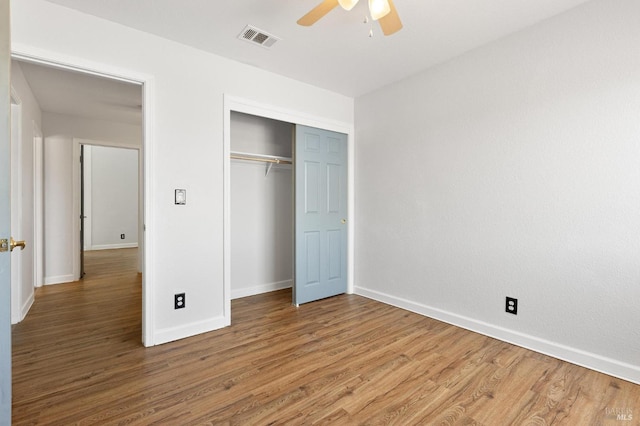 unfurnished bedroom with visible vents, wood finished floors, and baseboards