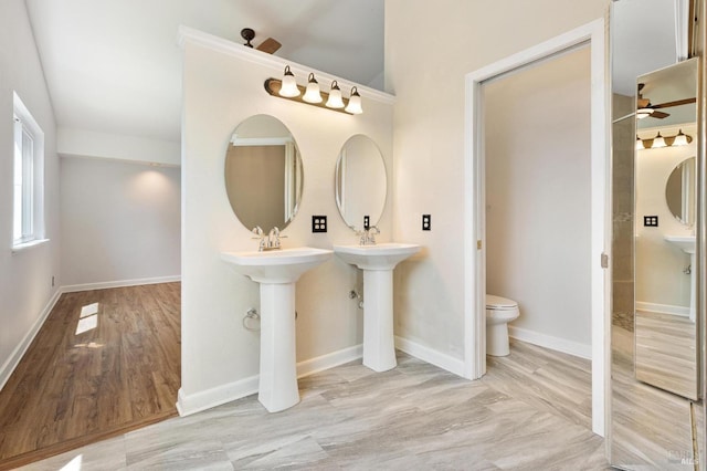 bathroom featuring baseboards, ceiling fan, and toilet