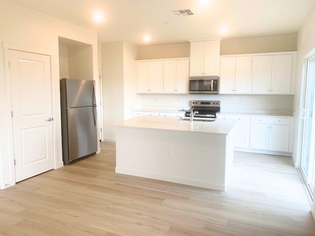 kitchen featuring a sink, light wood-type flooring, light countertops, white cabinets, and appliances with stainless steel finishes