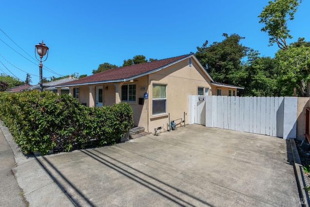 view of side of property featuring stucco siding and fence