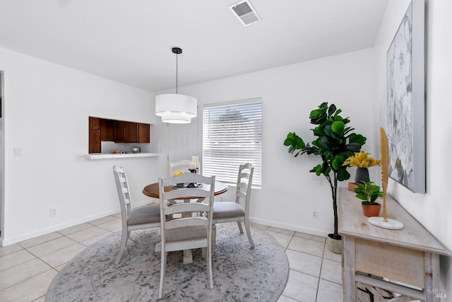 dining area featuring light tile patterned flooring, visible vents, and baseboards
