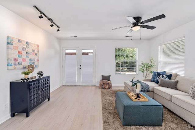living room with visible vents, ceiling fan, baseboards, light wood-type flooring, and rail lighting