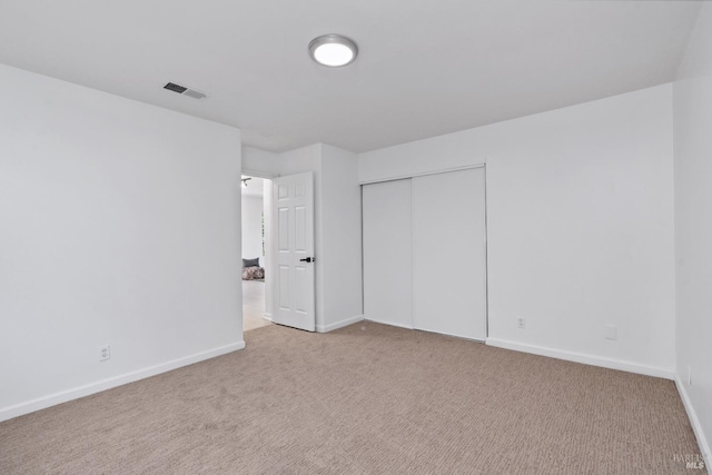 unfurnished bedroom featuring carpet flooring, a closet, visible vents, and baseboards