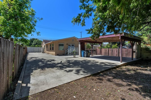exterior space with a carport, driveway, and a fenced backyard