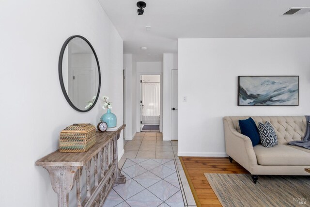 interior space with light wood-type flooring, visible vents, and baseboards