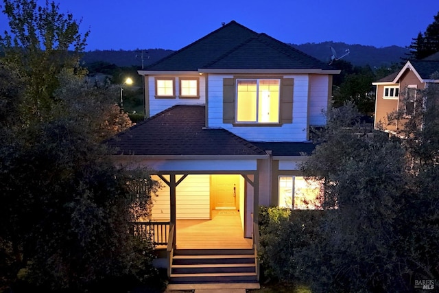 rear view of property featuring roof with shingles