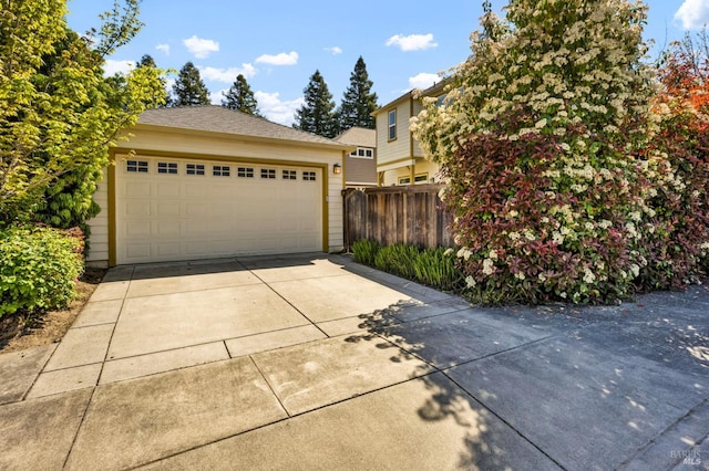 exterior space with fence, an outdoor structure, and a detached garage