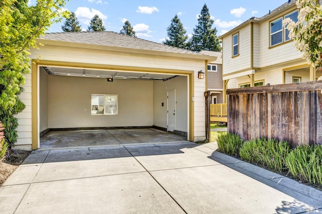 garage featuring fence and driveway
