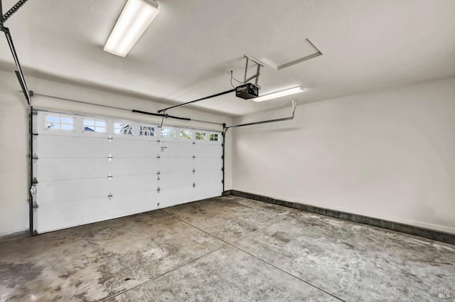garage with a garage door opener and baseboards