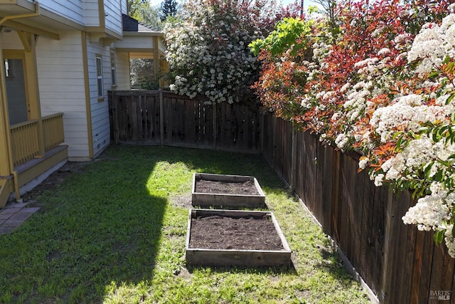 view of yard with a fenced backyard and a garden