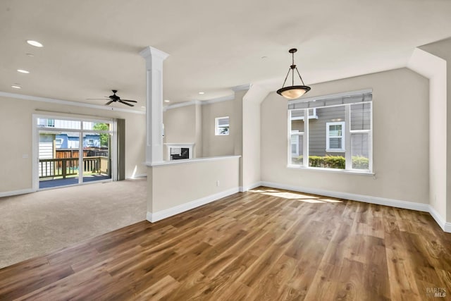 unfurnished living room featuring a fireplace, ceiling fan, wood finished floors, and baseboards
