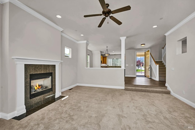 unfurnished living room featuring crown molding, a ceiling fan, carpet floors, and a healthy amount of sunlight