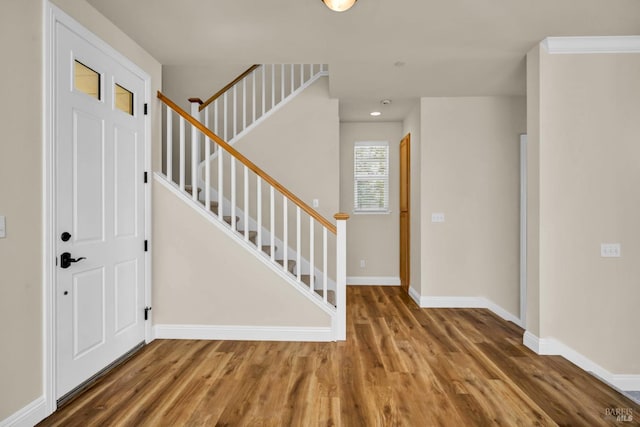 entryway with baseboards, recessed lighting, wood finished floors, and stairs