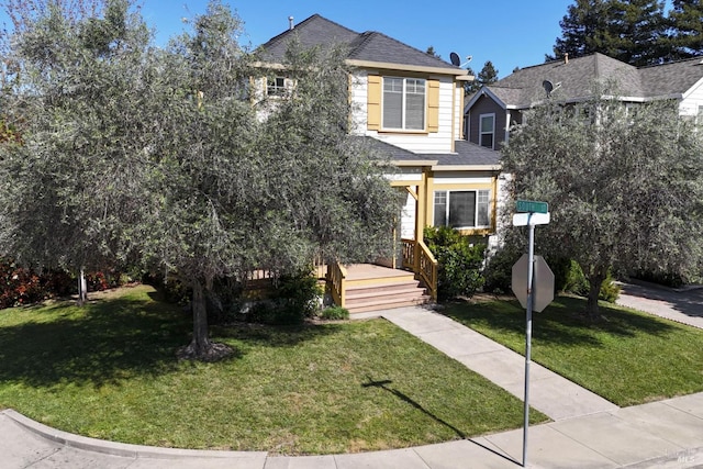 view of front of property with a front yard and roof with shingles