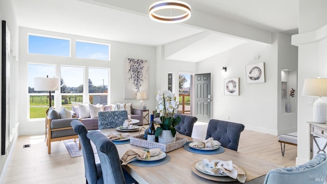 dining space featuring high vaulted ceiling, light wood finished floors, beamed ceiling, and baseboards
