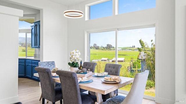 dining space with golf course view and light wood-style flooring
