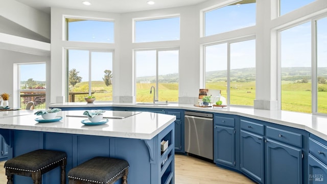 kitchen featuring recessed lighting, a sink, a healthy amount of sunlight, and blue cabinetry